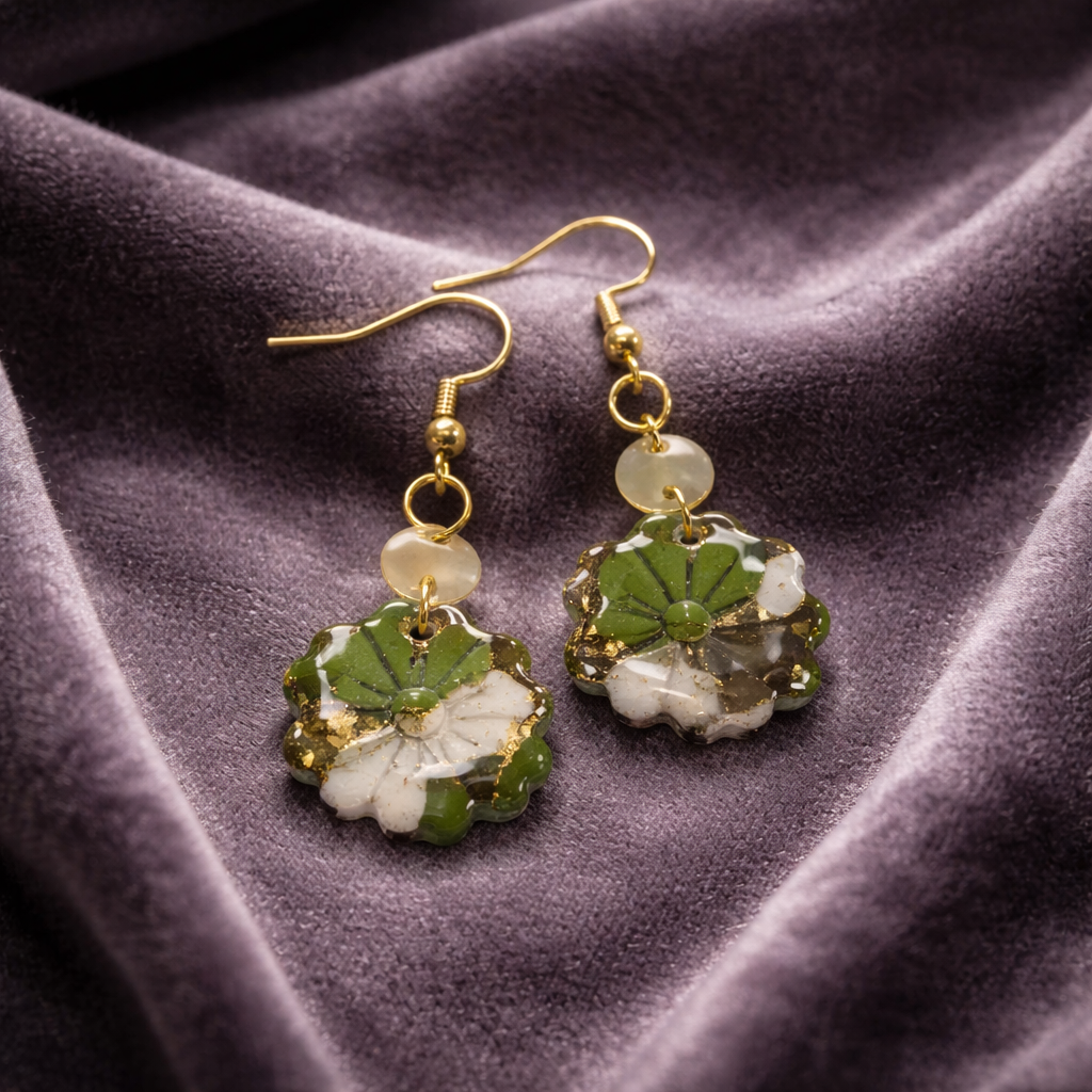 Green marbled flower earrings with gold accents on fabric