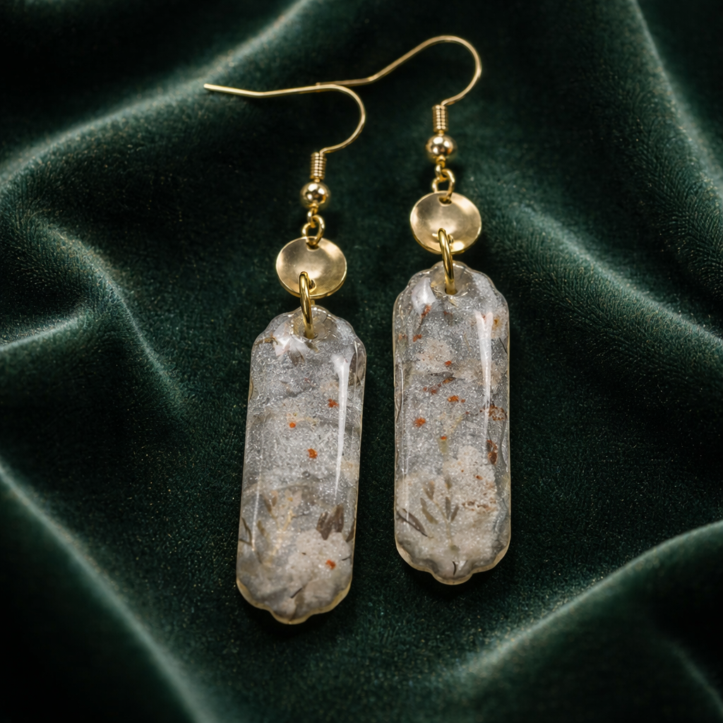 Floral pattern earrings with gold disk accents on dark fabric