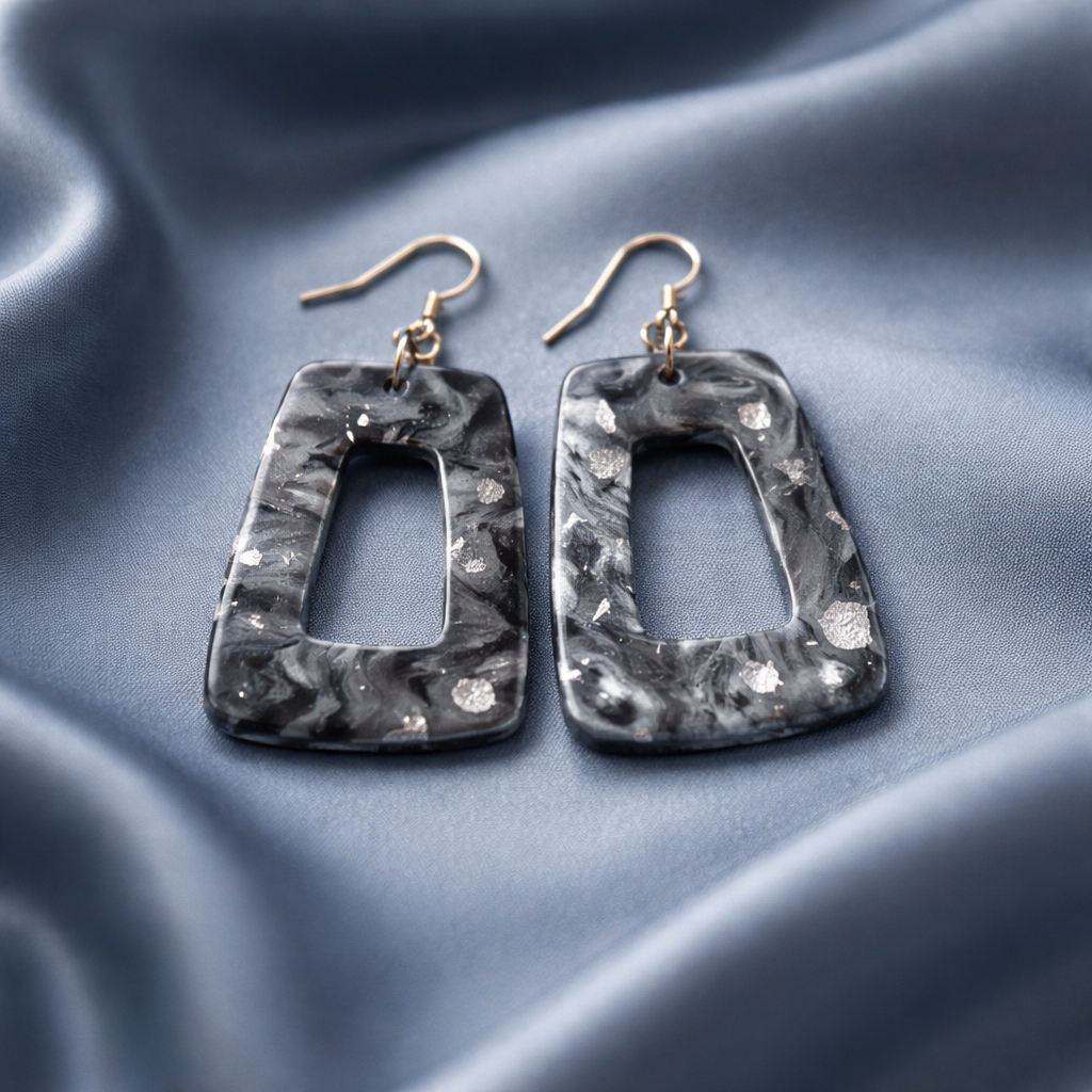Black marbled rectangle cutout dangle earrings with silver flecks and gold hooks