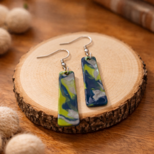 Navy, green, and silver swirl rectangle dangle earrings on wood slice.