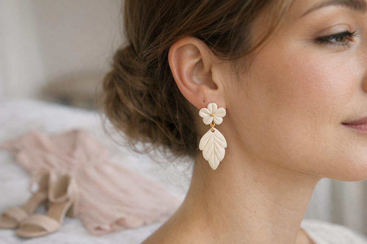 Blog Featured Image 100829 Cream teardrop polymer clay dangle earrings with a small gold accent styled for a spring wedding guest outfit.